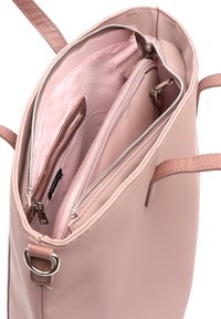 Lys pink tote taske med en glat overflade, to skulderstropper og et lynlåslukket hovedrum, der indeholder forskellige lommer og organisatoriske funktioner.