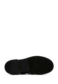 Schwarze Schuhsohle mit strukturiertem Gummibereich und leichtem Absatz, ausgestattet mit einer glatten Kante und dezentem Muster für besseren Halt.