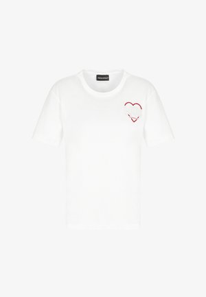 Maglietta bianca a maniche corte con un contorno a forma di cuore rosso e un design ricamato bianco e rosso con texture sul petto sinistro.