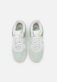 Nike Air sneakers featuring a soft mint green and white color scheme, leather and mesh materials, rounded shape, and lace-up closure.