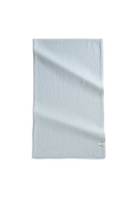 Lichtblauwe, gestructureerde stoffen deken, rechthoekige vorm met een zoomrand. Subtiel weefpatroon en een klein label in de onderste hoek.