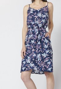 Kukallinen mekko, jossa on sinisiä ja vaaleanpunaisia kukkia tummansinisellä taustalla. Mekossa on hihaton malli, säädettävät olkaimet, joustava vyötärö ja taskut.