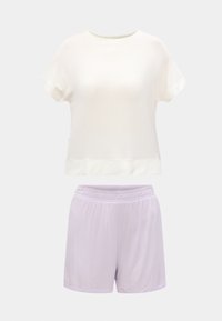 Λευκό μπλουζάκι με κοντά μανίκια και στρογγυλή λαιμόκοψη, σε συνδυασμό με σορτς ανοιχτό μωβ με ελαστική μέση, σε απλό φόντο.