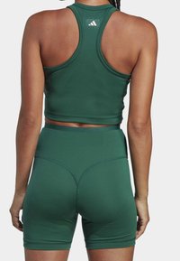 Set di top corto atletico e pantaloni shorts verdi, realizzato in materiale elastico, caratterizzato da un design a schiena scoperta e cuciture senza soluzione di continuità per il massimo comfort.