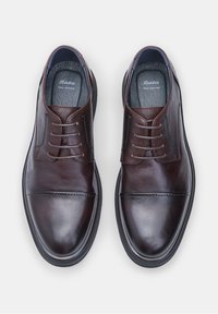 Chaussures en cuir marron avec une finition lisse, des orteils arrondis et un design à lacets. Comprend des semelles intérieures rembourrées et des semelles en caoutchouc.