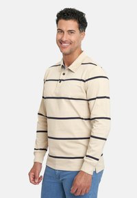 Camisa polo de manga larga beige con rayas horizontales en azul marino, que presenta un cuello con solapa, una tapeta de tres botones y un logo en el pecho.