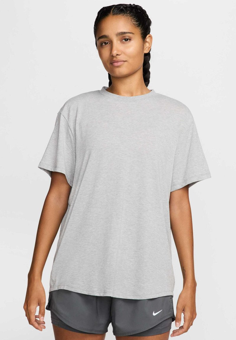 Camiseta de algodón gris claro con un corte relajado, mangas cortas y cuello redondo, combinada con pantalones cortos gris oscuro que tienen un logo.