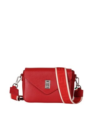 Sac bandoulière en cuir rouge avec rabat enveloppe, fermoir argenté, et large sangle rouge aux bords blancs avec une petite étiquette tricolore.