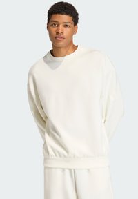 White sweatshirt made of soft fabric, featuring a crew neckline and elastic cuffs with a relaxed fit. Subtle branding on the sleeve.