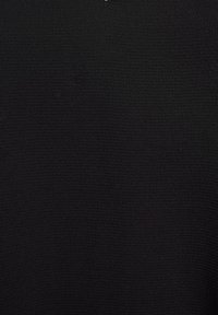 Černé polo tričko vyrobené z texturovaného materiálu, s tradičním límečkem a diskrétním logem na krku.