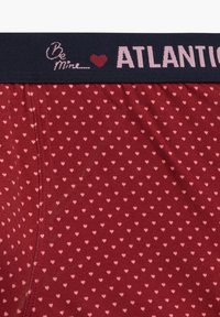 Czerwone majtki typu boxer z motywem małych różowych serc. Pas jest granatowy z napisem "Bądź mój" i "ATLANTIC" w jasnoróżowym kolorze.