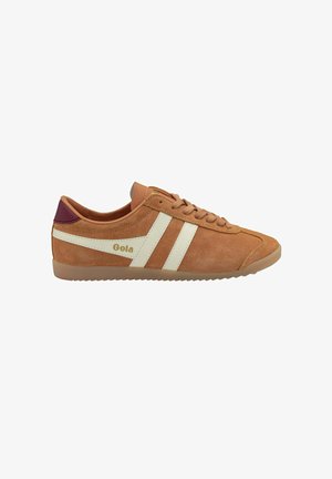 Sneaker in suede beige con strisce bianche e logo dorato. Presenta una linguetta marrone e un accento viola sul tallone, sole testurizzato per la trazione.