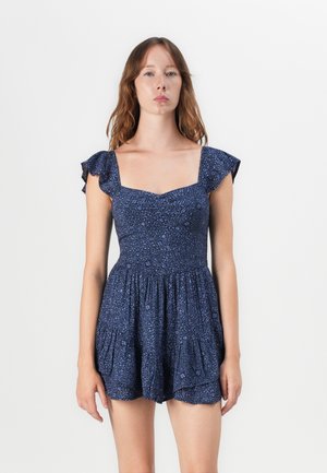 Robe bleu marine avec un décolleté carré, des manches à volants et une taille froncée. Présente un imprimé texturé et une jupe évasée.