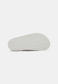Talon de pantof cu o bază din cauciuc alb și un model de tălpici în zigzag. Textură netedă cu un vârf rotund și un toc ușor ridicat.