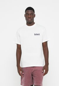 White cotton t-shirt with short sleeves, featuring a dark blue "Carhartt" logo on the left chest. Classic crew neck design.