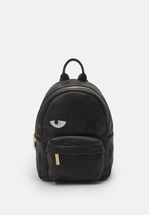 Sort læder mini rygsæk med front lynlåslomme, et broderet blåt øje med vipper og et sort stjernedesign på hovedrummet.