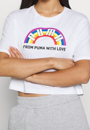 Biały krótki t-shirt z kolorowym wzorem tęczy z napisem "PUMA" powyżej i "FROM PUMA WITH LOVE" poniżej, napisanym pogrubioną czarną czcionką.