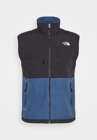 Schwarwest und blaues Fleece-Westen mit hohem Kragen, Frontreißverschluss und zwei seitlichen Reißverschlusstaschen. Mit dem North Face-Logo auf der Brust.