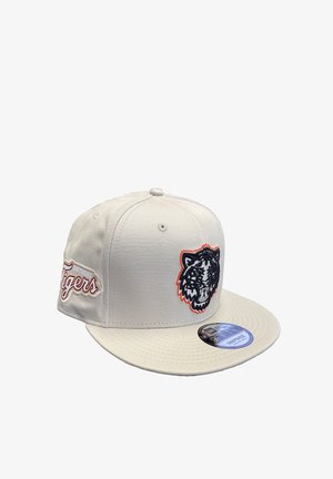 Weißes Baseballcap mit einem schwarzen Tiger-Logo und orangefarbenen Akzenten, flacher Schirm und strukturiertem Stoff. Mit einem Logo-Aufkleber auf dem Schirm.