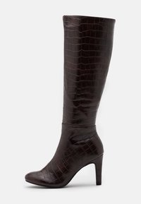 Bottes brunes montantes jusqu'au genou avec une texture brillante en relief croco, un bout pointu et un talon fin et haut, dotées d'un design de tige ajustée.
