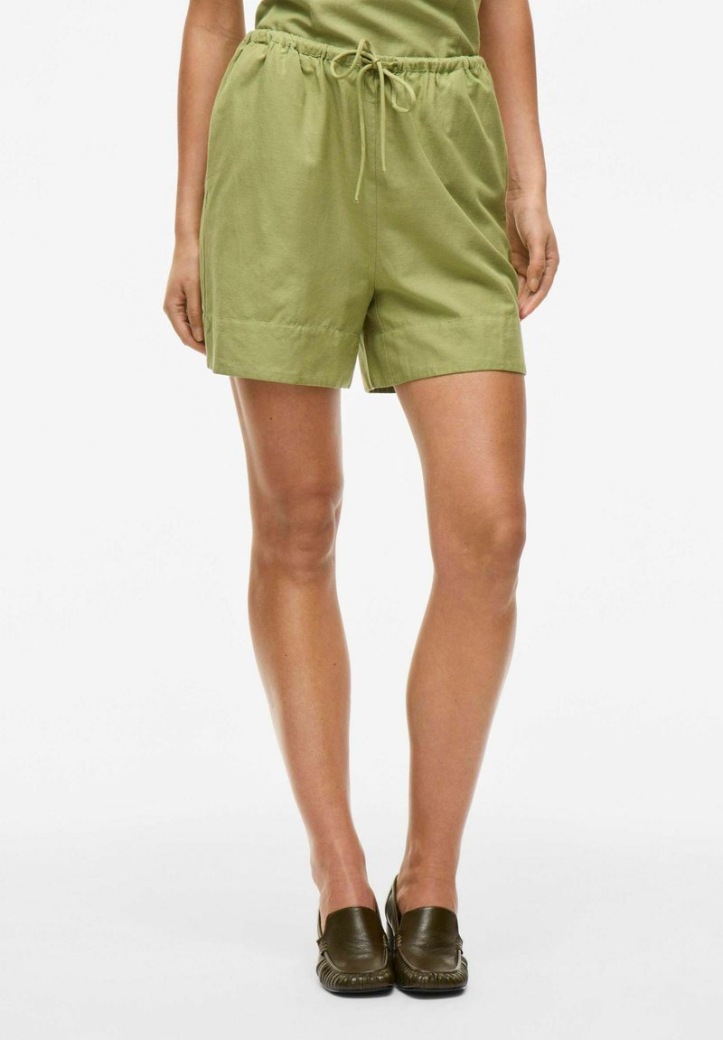 Grønne, letvægts shorts med elastisk talje og snøre. Har en afslappet pasform, sidelommer og en glat stoftekstur.