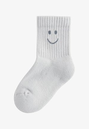 Hall hallist puuvillane sokk soonilise mustriga; välisküljel on tumehallis lihtne tikitud naeratav nägu. Põlveni ulatuv disain.