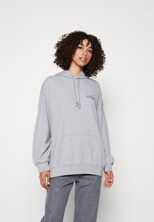 Lys grå hettegenser med frontlomme, snorhett, oversized passform og brodert blå logo på brystet, kombinert med grå vide bukser.