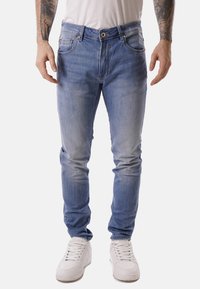 Jeans in denim azzurro chiaro con una vestibilità slim, caratterizzati da un tradizionale design a cinque tasche, sbiadimenti sottili e un bottone di chiusura in vita.