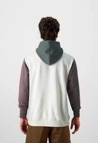 Hooded sweatshirt featuring a light grey body, dark green hood, and brown sleeves. Made of soft fabric with ribbed cuffs and hem.