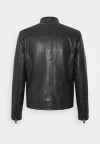 Svart läderjacka med en mjuk textur, ståkrage och dragkedjeärmar. Har en figursydd design och minimal sömnad på baksidan.