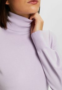 Lila coltrui van zachte stof; voorzien van aansluitende manchetten en een geribde hals, met een gladde, rekbare textuur.