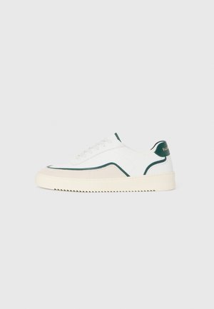Niedriger weißer Sneaker mit dunkelgrünem Besatz, cremefarbiger Sohle und Schnürung vorne, seitlich auf hellgrauem Hintergrund gezeigt.