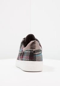 Zapatillas de cuadros con un patrón en negro, gris y azul, que cuentan con una suave tapa de talón gris y una suela de goma blanca texturizada.