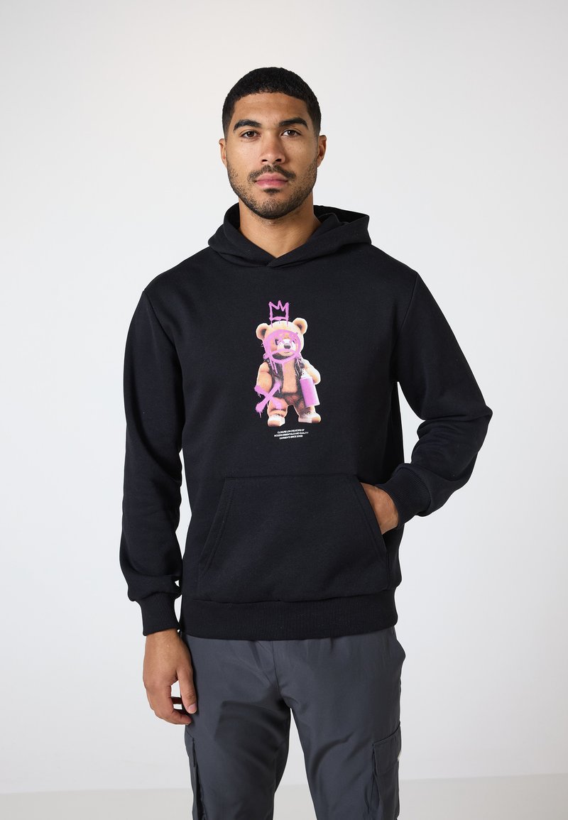 Schwarzer Hoodie aus weichem Material mit einem bunten Bären-Graphic, der eine Krone und eine Sprühdose hält, vorderer Kängurutasche, gerippten Bündchen.