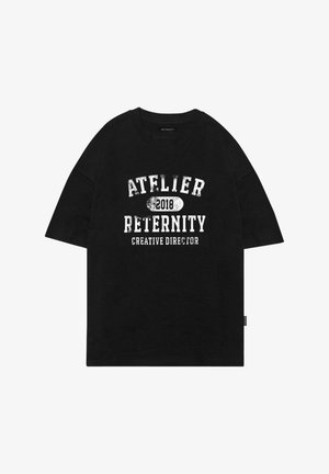 Mustmust vaba t-särk, millel on valge kulunud tekst: "ATELIER RETERNITY 2018 LOOVJUHT" keskelt ees. Lühikesed varrukad.