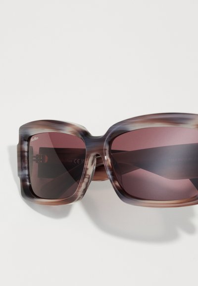 Brown and cream tortoiseshell sunglasses with oversized square frames and dark purple lenses. Features subtle branding on the left lens.