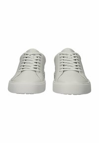 Zapatillas de cuero blancas con un diseño de perfil bajo, cordones planos y una suela de goma texturizada. Estilo minimalista con líneas limpias y sin marcas visibles.