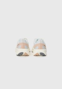 Lysegrå sneakers med pink detaljer, tekstureret mesh-overdel, polstret krave og en cremeguldsål med grå og pink dekoration.
