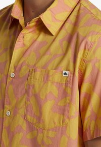 Korte mouwen overhemd in geel en roze met bloemmotief, button-down kraag, één borstzak en subtiele logo-tag op de zak.