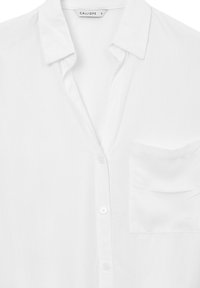 Camicia bianca con bottoni, colletto e taschino sul petto, realizzata in tessuto leggero, taglia piccola, marca Calliope.