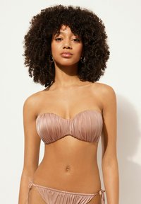 Bikini utan axelband i mjukt nude-tyg med veckad design; toppen har en rundad form och botten har justerbara snören vid höfterna.