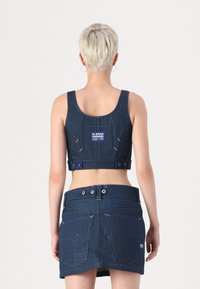 Denim kratka majica s kvadratnim izrezom i gumbima na hrbtu, s logotipom G-Star Originals; u paru s odgovarajućom traper suknjom.