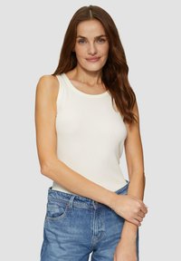 Weißes, ärmelloses Tanktop aus geripptem Material mit rundem Ausschnitt, kombiniert mit hellblauen Jeans, glatte Textur, lässige Passform.