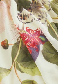 Material floral cu flori vibrante de roșu și roz, frunze verzi și motive de fluturi pe un fundal deschis, cu o suprafață moale și texturată.