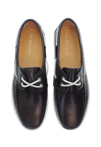 Svarta läderskor med en slät yta, vita snören och en kontrasterande sula. Innehåller varumärkets logotyp invändigt och har en rundad tådesign.