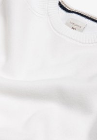 Hvid bomulds-sweatshirt med ribbet halsudskæring. Har en marineblå og cremefarvet detalje langs kraven. Etiketten med "DAN JOHN" er synlig.
