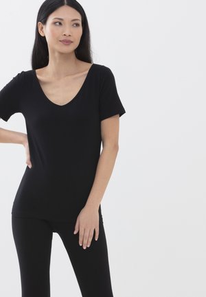 Zwarte korte mouwen V-hals t-shirt, fitted stijl, gemaakt van gladde stof, gecombineerd met zwarte leggings; model staat met één hand op haar heup.