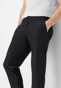 Zwarte broek met een gladde textuur, voorzien van zijzakken, een knoopsluiting en een getailleerde pasvorm, gecombineerd met een wit overhemd.