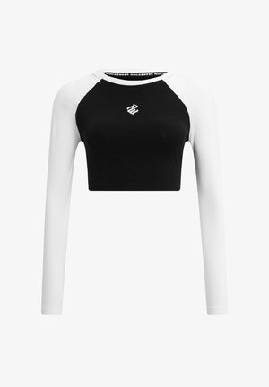 Mustvalge pikad varrukad lühikesed tipp, millel on ümar kaelus, kontrastsete raglanvarrukatega ja väike logo rinnal. Pehme tekstuur.