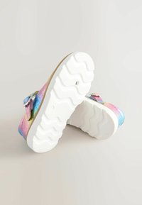 Colorful, iridescent clogs with a white, textured sole. Features adjustable strap and soft upper material in pink, blue, and green shades.